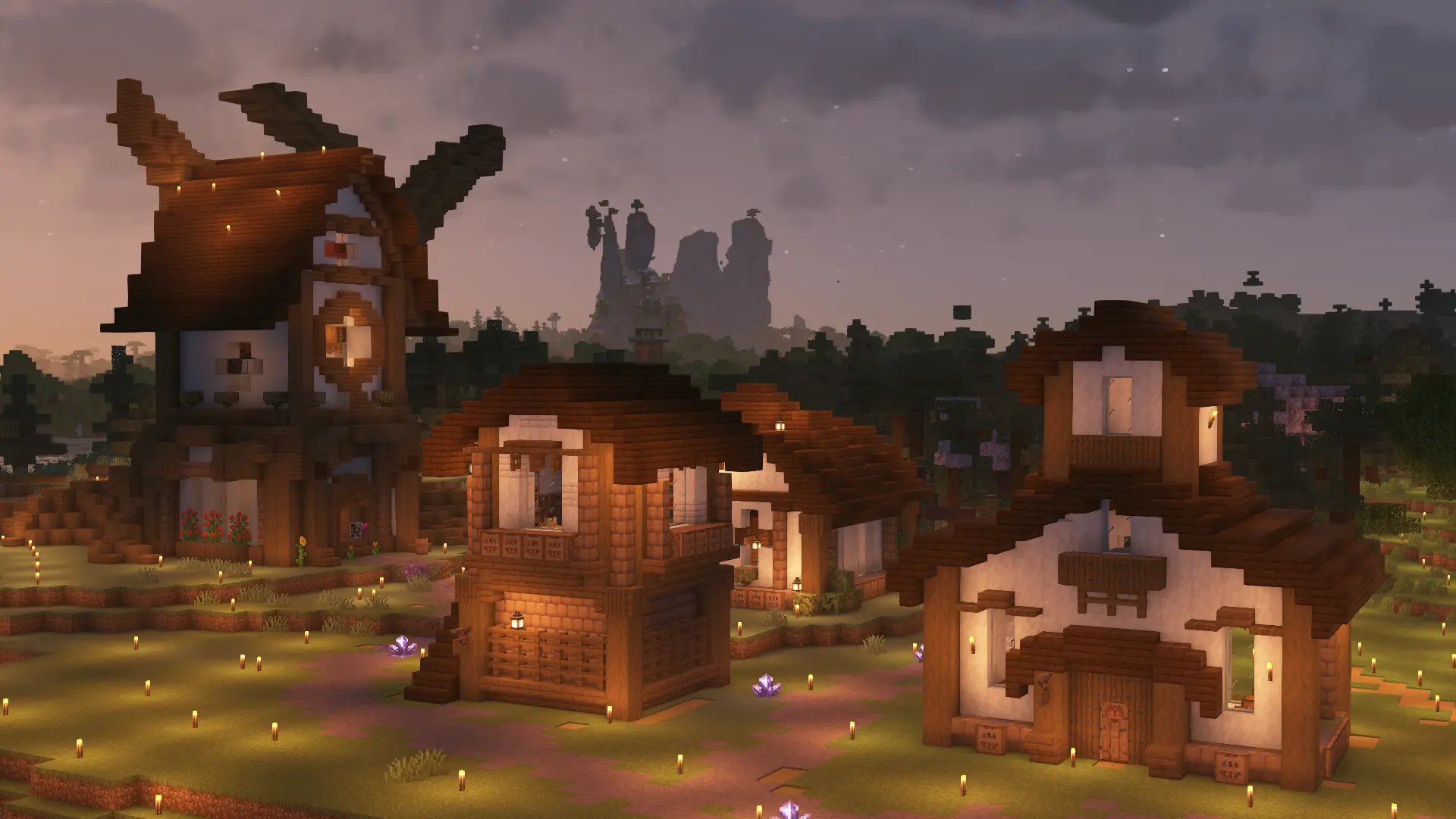 A zoomed out shot of the first image, with multiple other buildings in the same style forming a village. Purple amethyst crystals glow along the ground and a purple path marks the village roads.